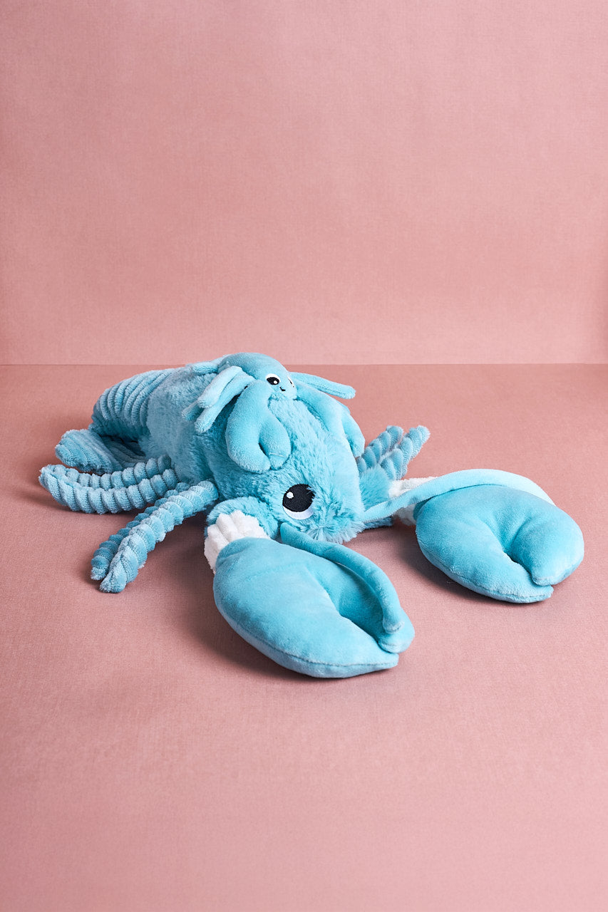 Blue plush octopus toy on a pink background