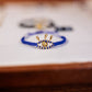 Blue beaded bracelet with gold accents on a wooden surface