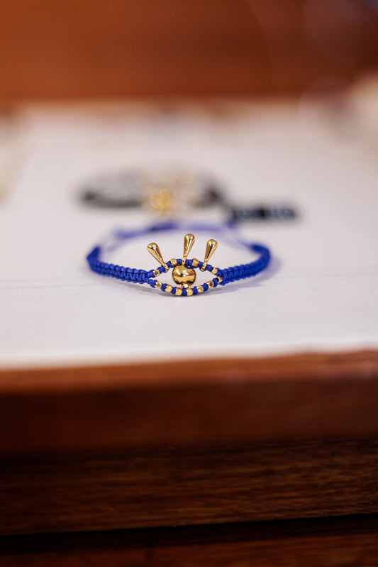 Blue beaded bracelet with gold accents on a wooden surface