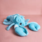 Blue plush octopus toy on a pink background